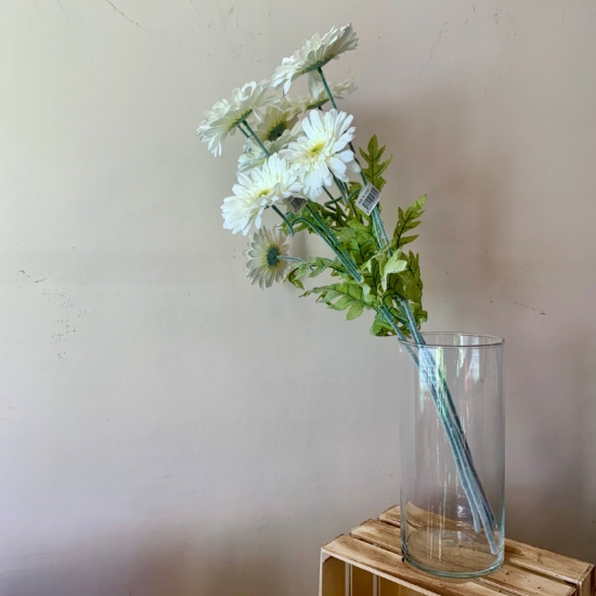 Flores blancas de gerber artificial en un jarrón transparente